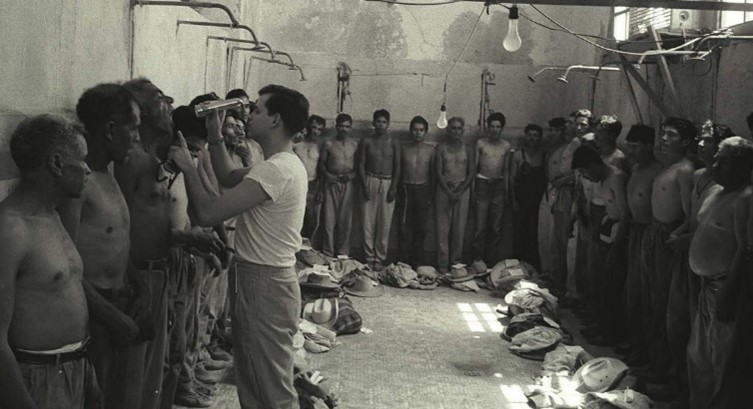 An Official Examines a Bracero's Teeth and Mouth with a Flashlight