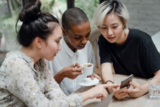 Three women looking at a smartphone