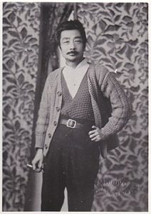 Lu Xun wearing a sweater and holding a cigarette