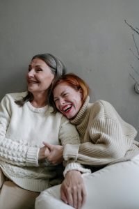 Two women smiling and holding hands