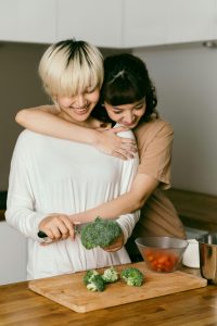 A couple of women hugging in a kitchen