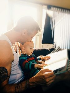 A person reading a book to a baby